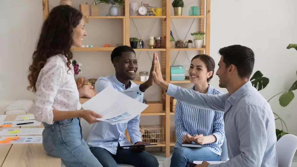 employees high fiving employees high fiving