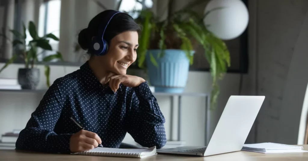 smiling-woman-headphones-laptop-plants-notebook